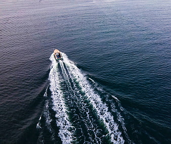 Aerial View of Small Boat Leaving White Wake on Blue Ocean