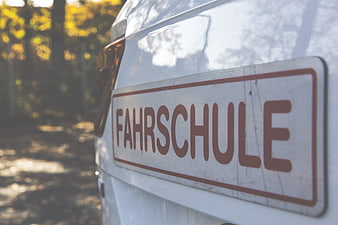 Close-up of German Fahrschule Driving School Sign on White Car