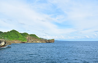 Lush Green Cliffs Overlooking Blue Ocean and Sky
