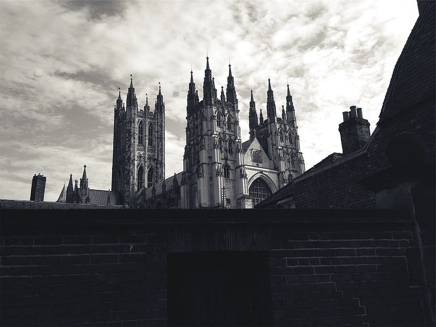Black and white gothic cathedral spires behind brick wall