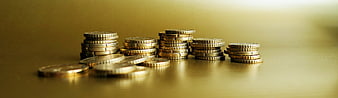 Stacks of gold coins on a reflective surface with copy space