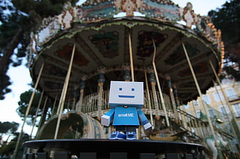 Small ME Paper Toy Figure Standing In Front Of Vintage Carousel