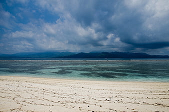 Tropical Beach with Turquoise Water and Dramatic Cloudy Sky