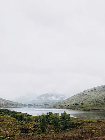 Misty Mountain Lake Landscape with Green Hills and Fog