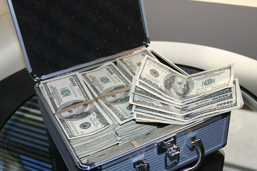 Open briefcase filled with stacks of hundred dollar bills