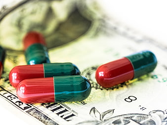 Red and green capsules on a US dollar bill