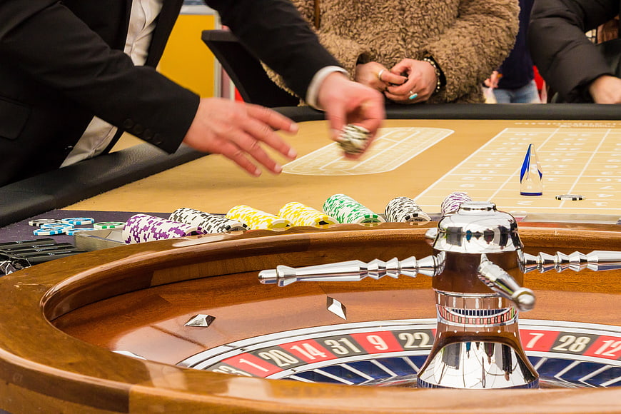 Casino Dealer Handling Chips at Roulette Table