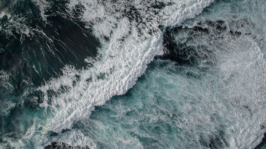 Aerial View of Turbulent Ocean Waves and White Sea Foam