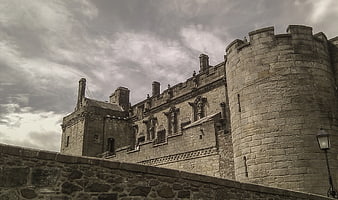 Historic Stone Castle Tower Under Dramatic Cloudy Sky