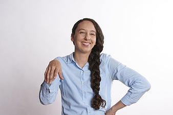 Smiling woman with long braid in light blue shirt on white background