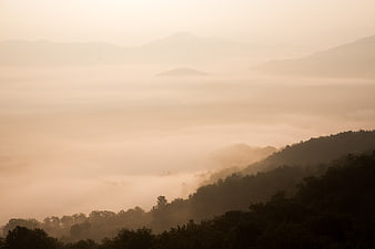 Misty mountain landscape with sea of fog at sunrise