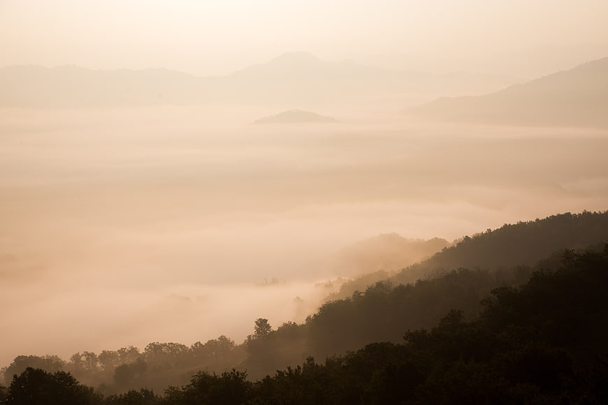 Misty mountain landscape with sea of fog at sunrise