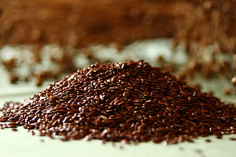 Close-up of brown flaxseed pile on a light surface