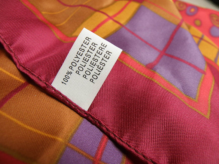 Close-up of colorful plaid scarf with 100% polyester label