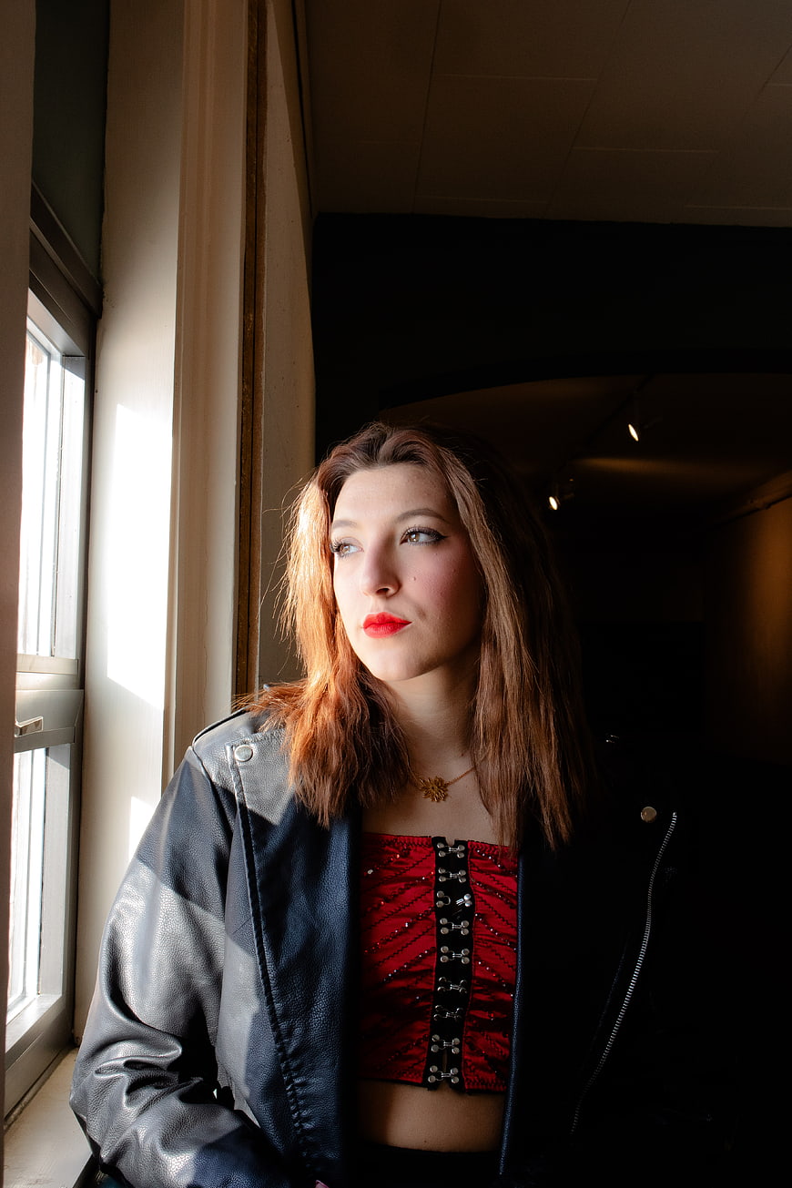 Woman in Leather Jacket by Window