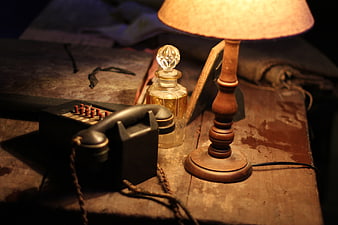 Vintage Telephone and Lamp on Old Wooden Desk