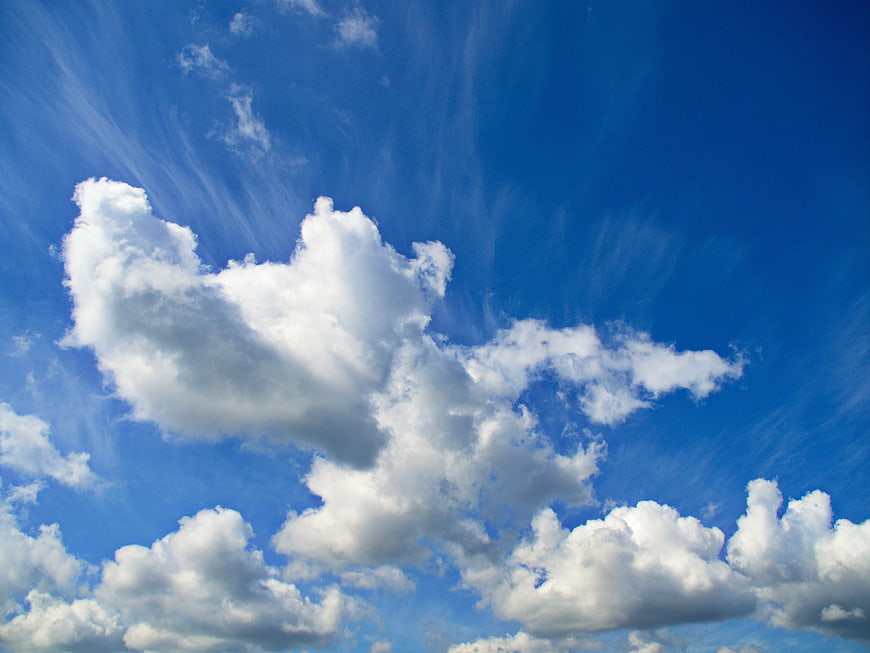 Fluffy White Clouds Against Vibrant Blue Sky Background
