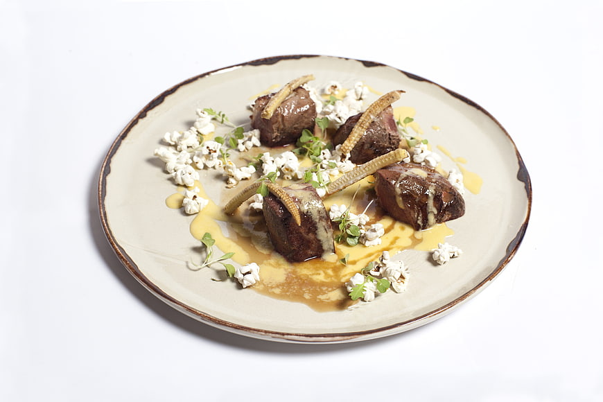 Gourmet Beef Tenderloin with Popcorn and Sauce on White Plate