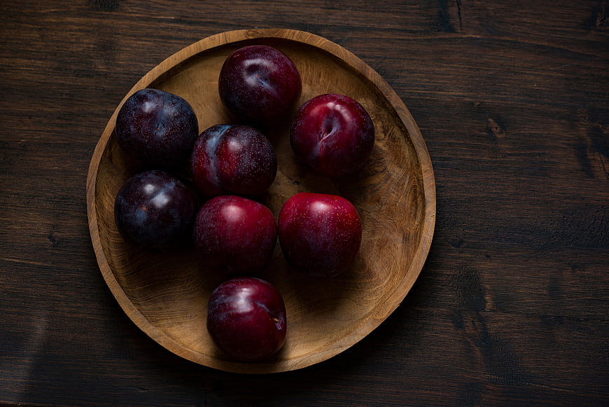 Fresh Red Plums in Wooden Bowl on Dark Table