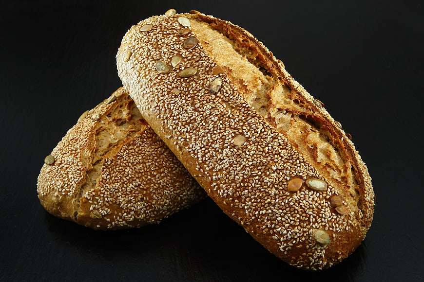 Freshly Baked Whole Wheat Bread with Seeds on Black Background