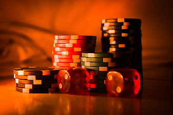 Stacks of Casino Chips and Red Dice on Table