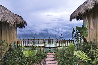 Bamboo Huts with Thatched Roofs Overlooking Misty Mountain Valley