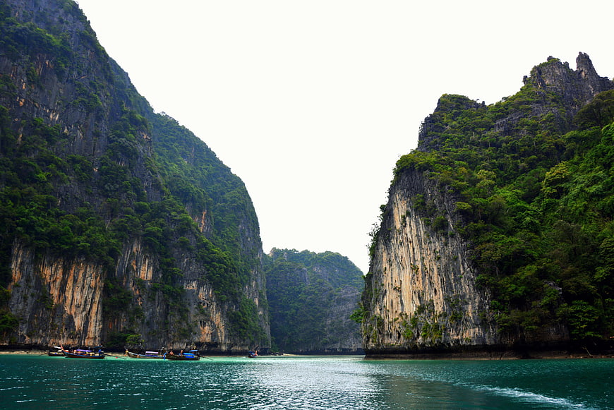 Tropical limestone cliffs and turquoise water with longtail boats
