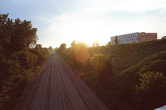 Sunset over railway tracks with modern building in background
