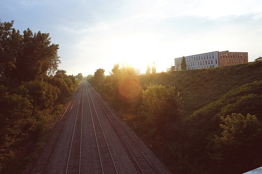 Sunset over railway tracks with modern building in background