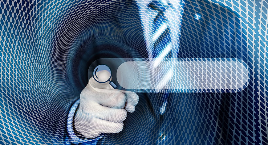 Hand holding magnifying glass over digital search bar