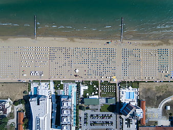 Aerial view of organized beach umbrellas and coastal hotels