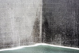 Waterfall cascading over concrete wall into pool