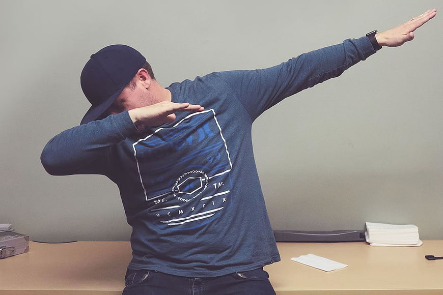 Man in Blue Shirt and Cap Doing the Dab Dance Move