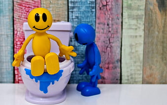 Yellow and Blue Smiley Figures in Miniature Toilet Scene