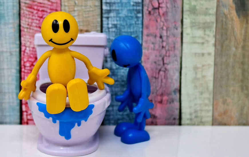 Yellow and Blue Smiley Figures in Miniature Toilet Scene