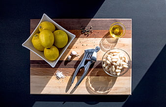 Top view of white beans, lemons, and garlic on wooden board