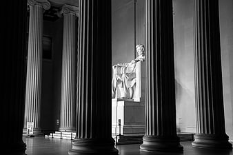 Black and white photo of the Lincoln Memorial statue framed by columns