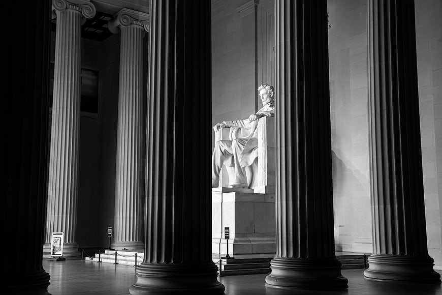 Black and white photo of the Lincoln Memorial statue framed by columns