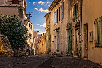 Narrow cobblestone alley in historic French village with rustic buildings