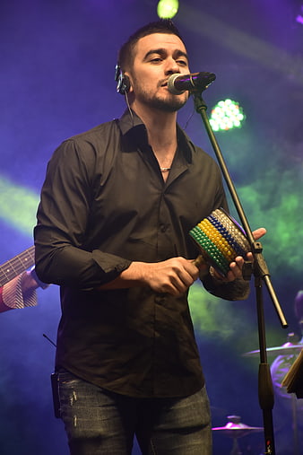Male Singer Performing on Stage with Percussion Instrument