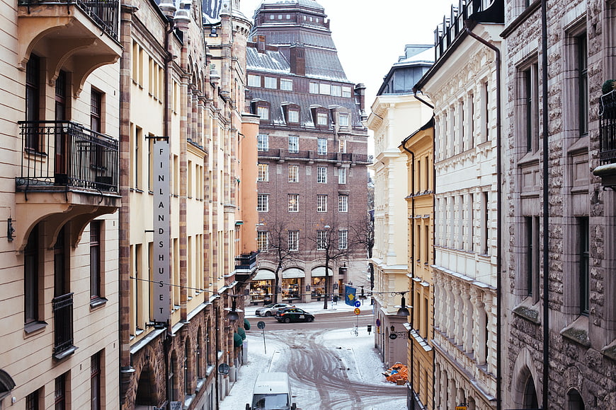 Snowy European Street with Historic Architecture and Finlandshuset Sign