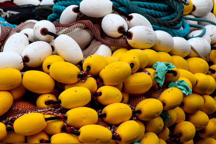 Close-up of yellow and white fishing buoys with nets