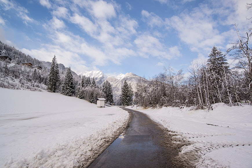 Winding Winter Road Through Snowy Alpine Forest