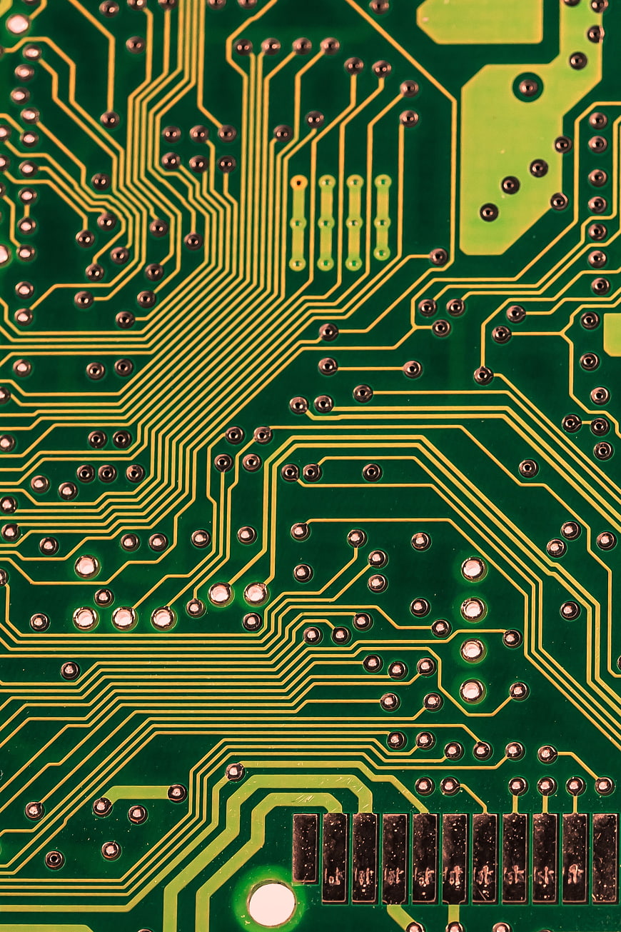 Macro shot of green printed circuit board with gold traces