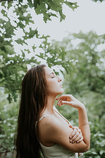 Serene woman meditating outdoors with eyes closed in nature