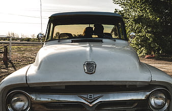 Couple kissing in vintage white Ford truck at sunset