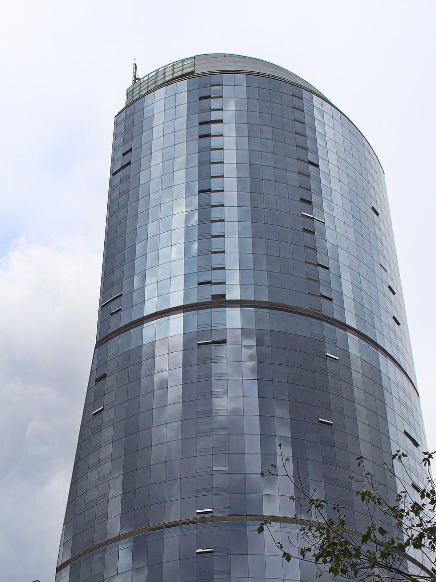 Low angle view of modern curved glass skyscraper