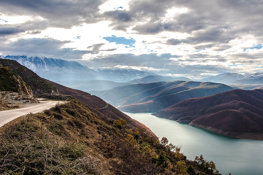 Scenic Mountain Road Overlooking Lake and Snowy Peaks