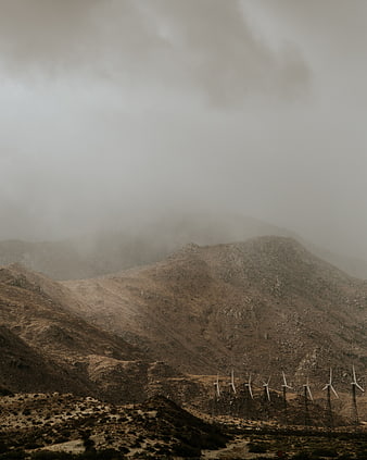 Wind turbines on foggy mountain ridge landscape