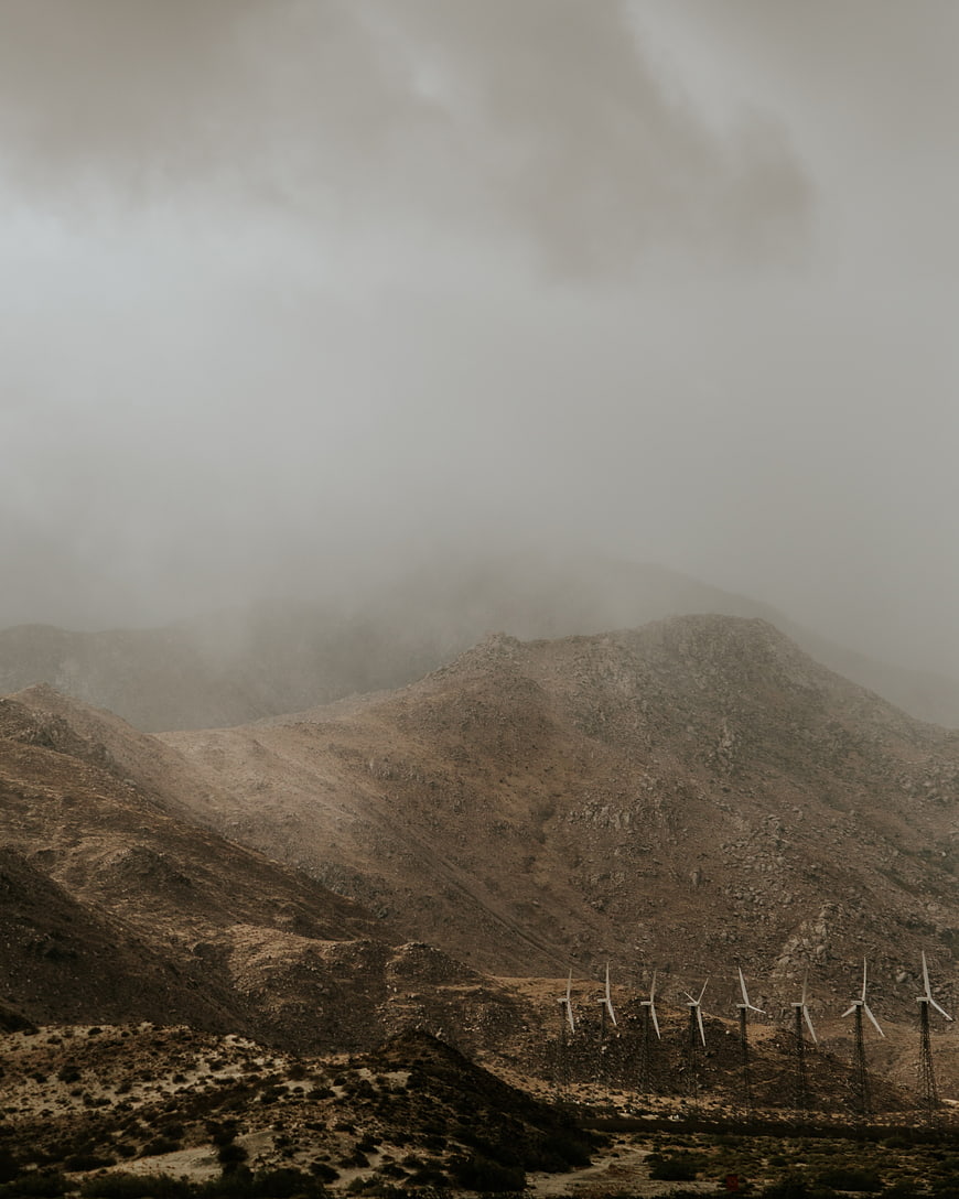 Wind turbines on foggy mountain ridge landscape